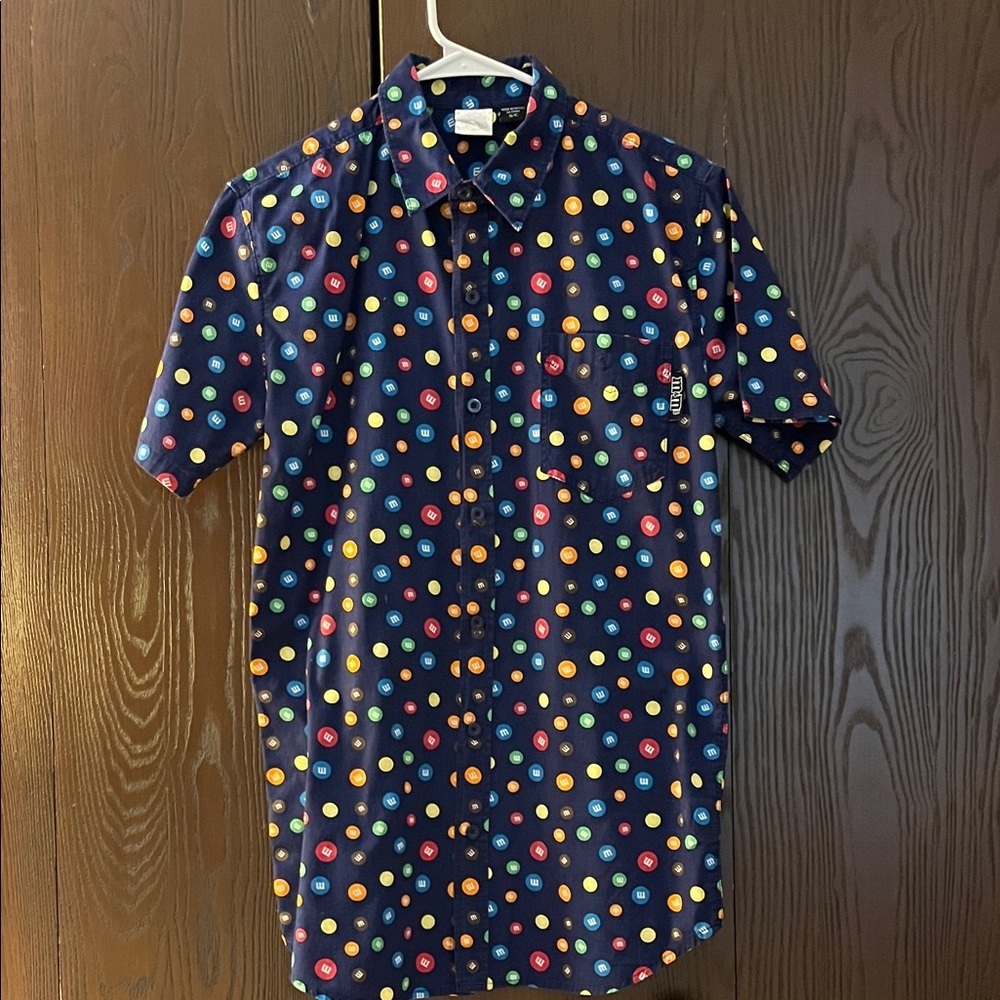 M&M men’s short sleeved navy blue shirt with colored M&M all over. Size Small